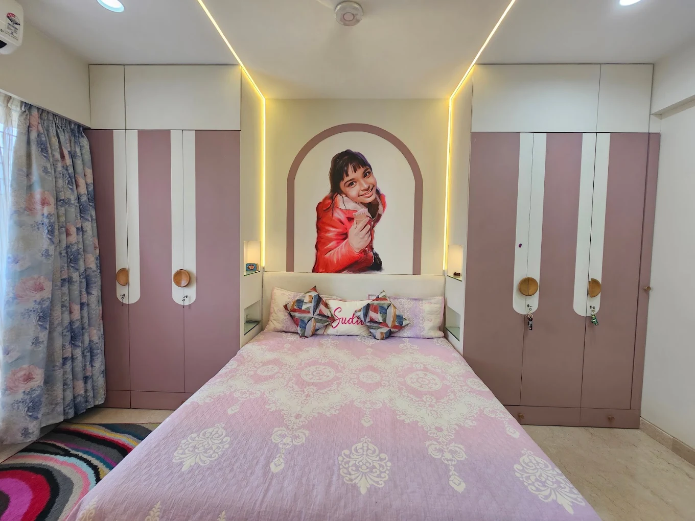 Children’s bedroom with lilac wardrobes, cove lighting and painted portrait mural