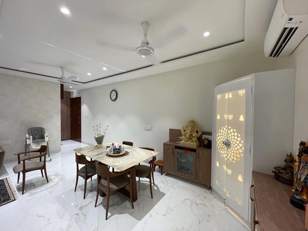Dining room with a back-lit jaali mandir door and marble table